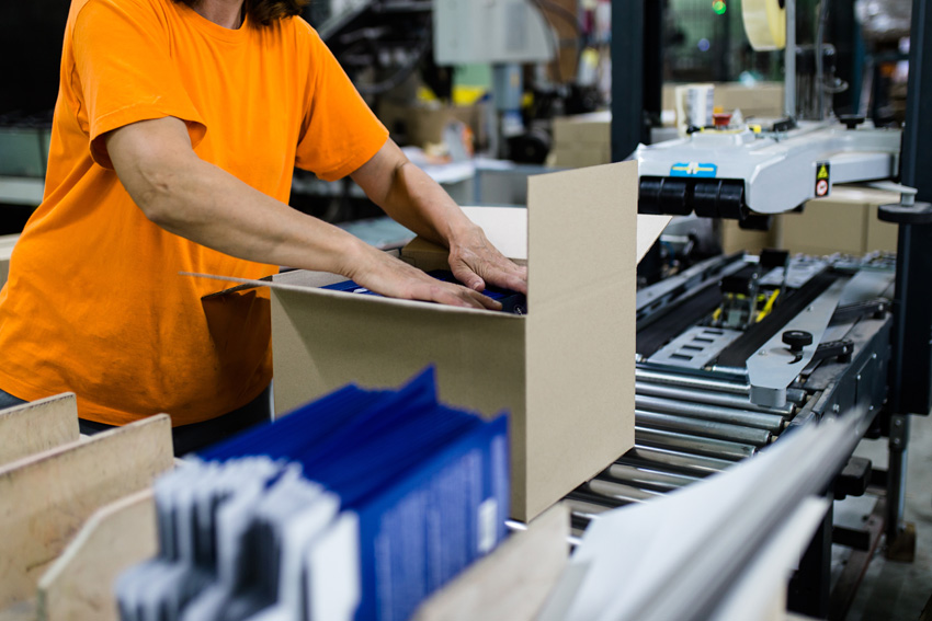 Employee With Orange Shirt Checking Box of Products for Defects